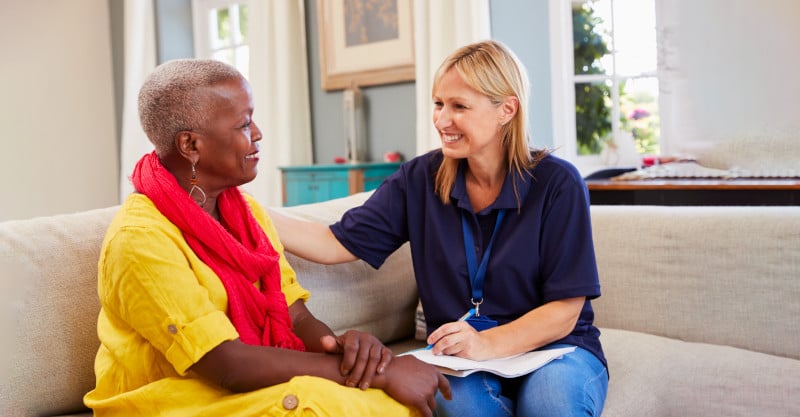 AST advisor sitting on a sofa with a foster carer